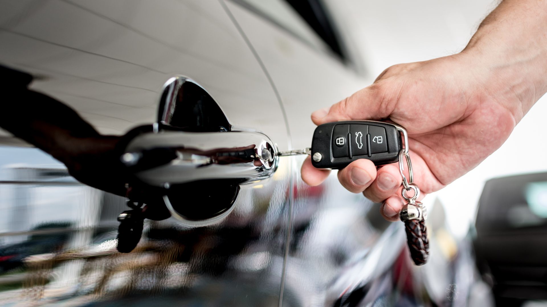 Car key fob near car door handle with remote lock button